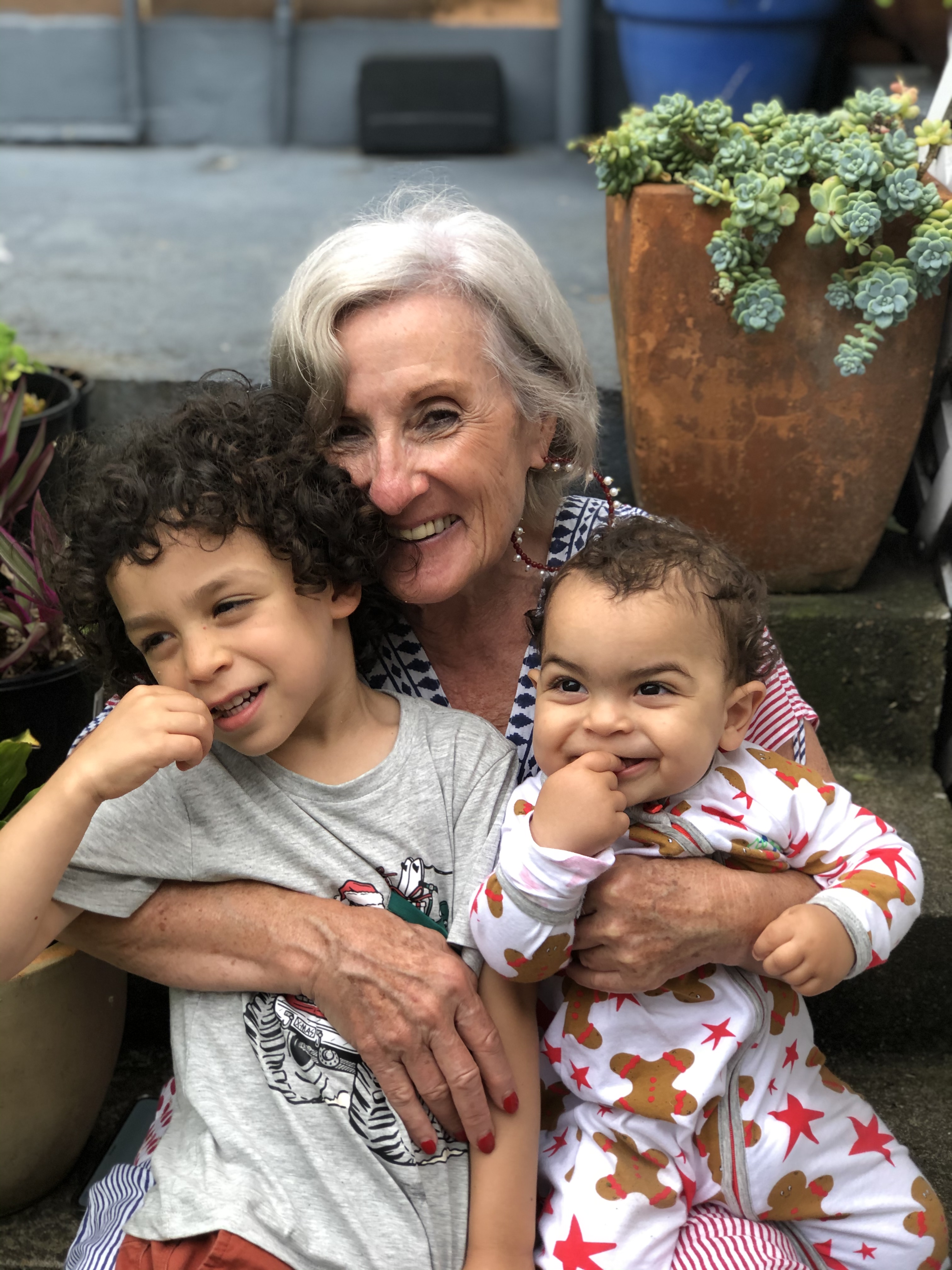 A Nanna holding two children, all laughing together